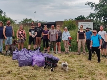 A group gathered after a litter pick, with bags of rubbish.