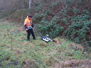 Worker with a machine that surveys the ground.