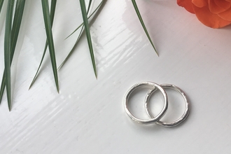Silver rings on table with flowers