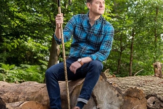 Matt Baker sitting in the forest.