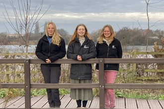 Three staff members of Wilder Trent project standing on boardwalk at nature reserve