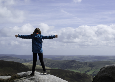 Woman on mountain, arms outstretched