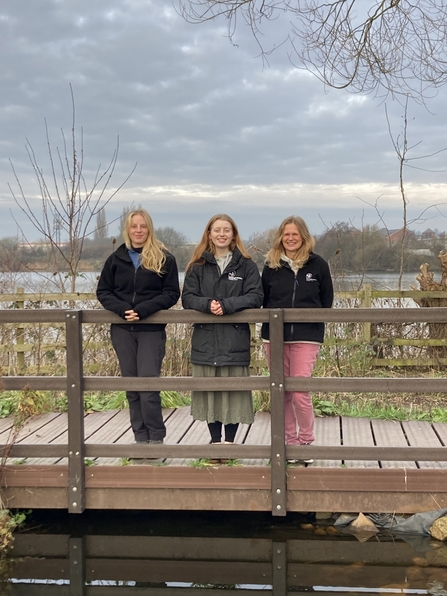 Three staff members of Wilder Trent project standing on boardwalk at nature reserve