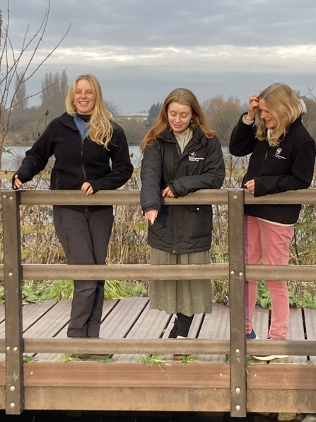 three of the project team on a pond dipping platform looking into the pond